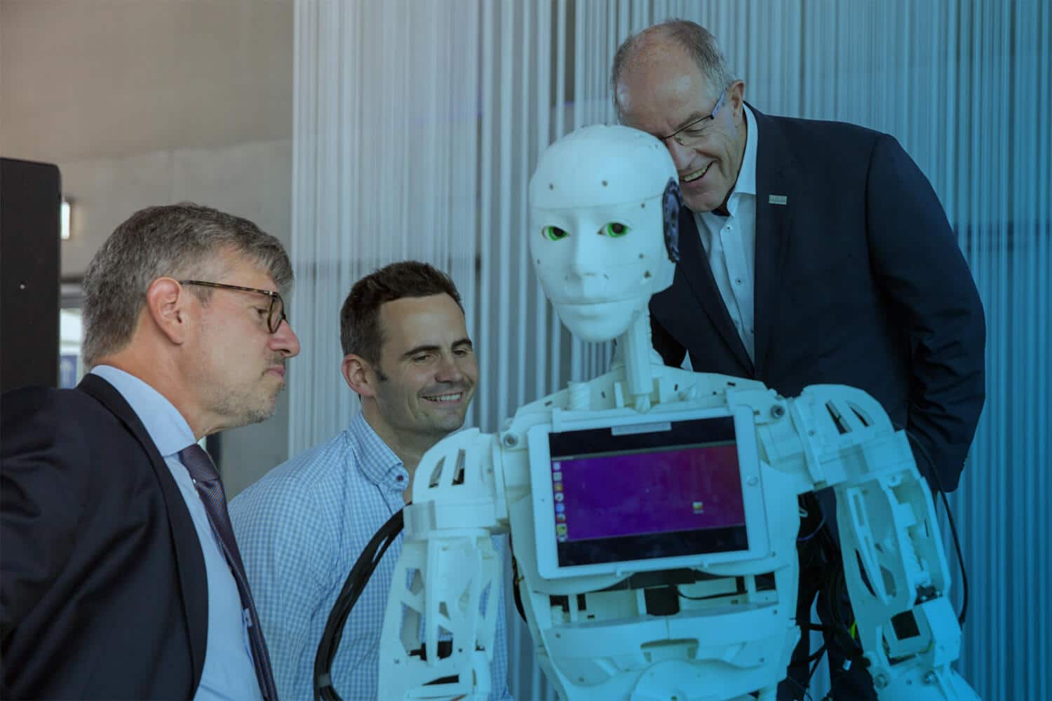 Roboter Bob ist einer der IOX Prototypen für die Messe und wird hier von drei Leuten betrachtet